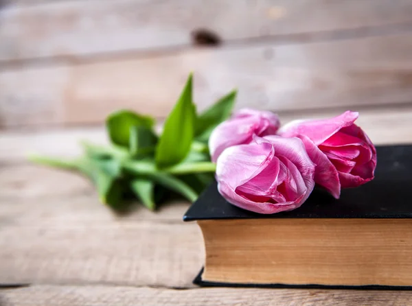 Flowers. pink tulips on a pile of old books — Stock Photo, Image