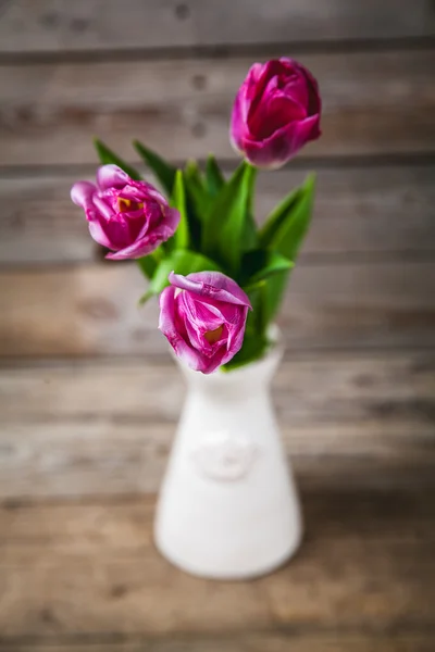 Vase of natural tulips. flowers on a wooden background — Stok fotoğraf