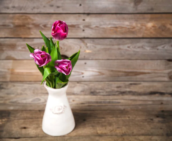 Vase of natural tulips. flowers on a wooden background — Stok fotoğraf