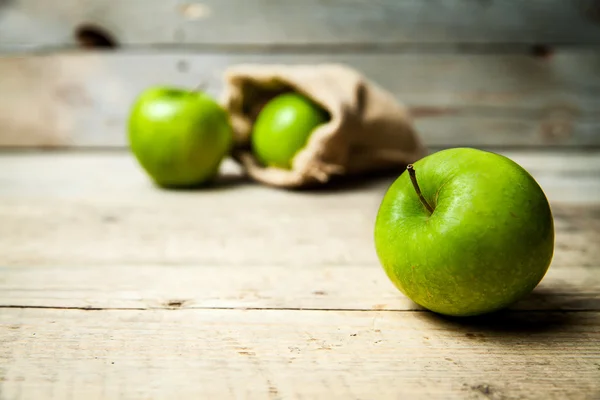 Früchte. reife grüne Äpfel mit Klette, auf Holzgrund — Stockfoto