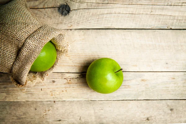 Früchte. reife grüne Äpfel mit Klette, auf Holzgrund — Stockfoto