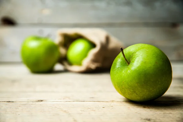 Früchte. reife grüne Äpfel mit Klette, auf Holzgrund — Stockfoto