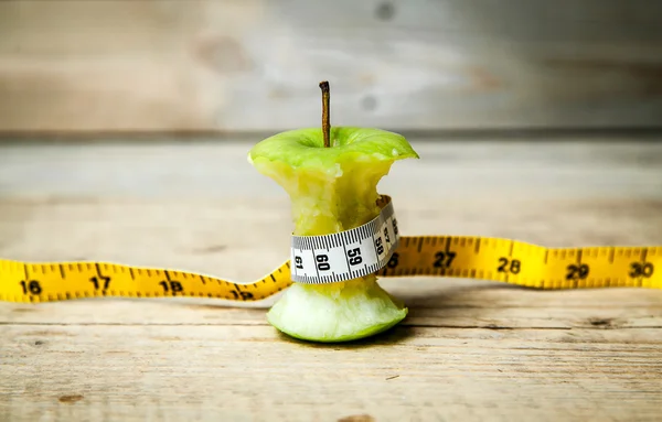 Fruta. núcleo de manzana con una cinta métrica a su alrededor . —  Fotos de Stock