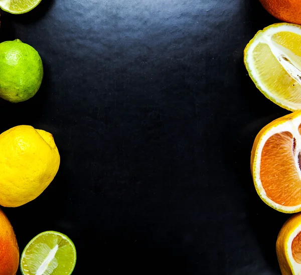 Gesneden citrusvruchten op een zwarte achtergrond. voedsel — Stockfoto