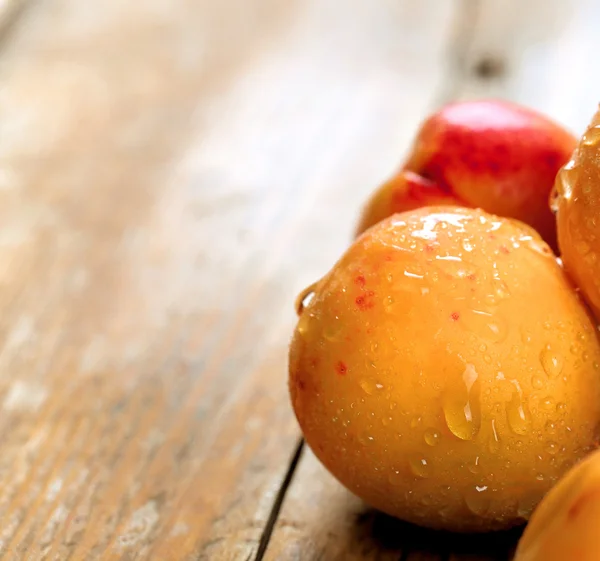 Aprikose. Bio-Früchte mit Blatt auf Holzgrund — Stockfoto
