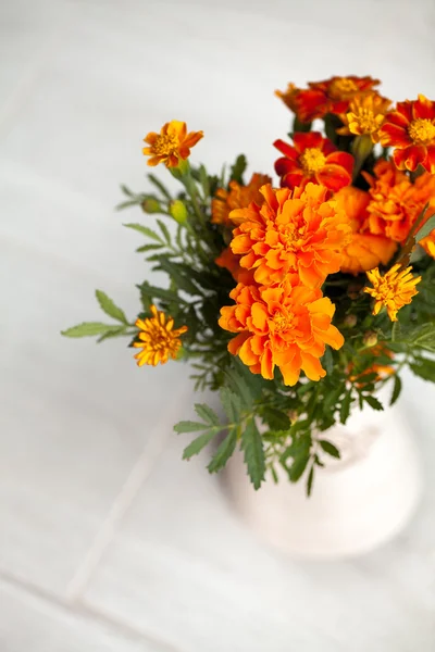 Gri arka plan üzerinde vazoda marigolds çiçekler — Stok fotoğraf