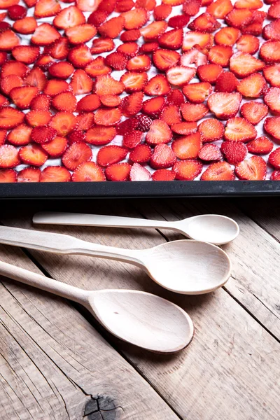 Fruta. fresa en rodajas con cucharas de madera — Foto de Stock