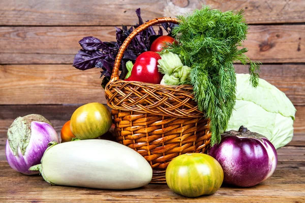 Verduras frescas en la cesta sobre fondo de madera —  Fotos de Stock