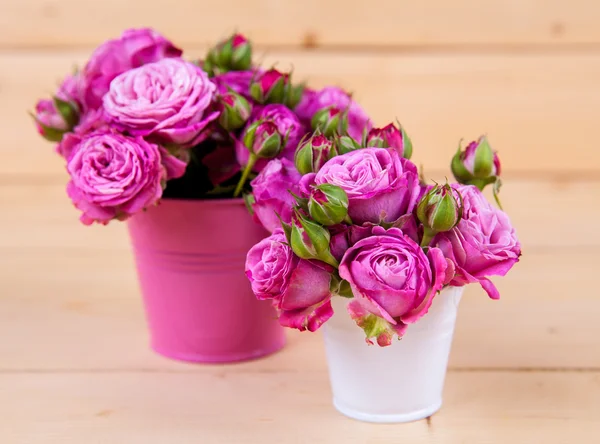 Pink roses in a vase on wooden background — Stock Photo, Image