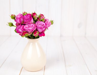 Beyaz ahşap zemin üzerinde taze çiçek gül