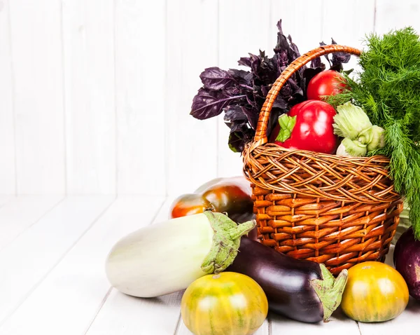 Verduras frescas en la cesta sobre fondo de madera blanca — Foto de Stock