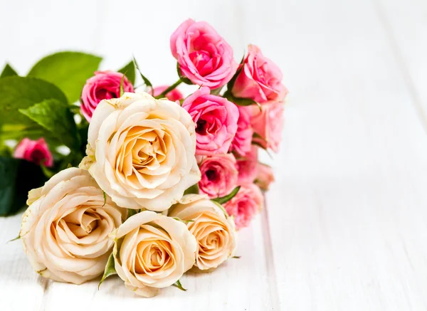 Rosas em pranchas de madeira branca fundo. flores — Fotografia de Stock