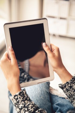 Holding ve boş ekran ile tablet kullanarak kadın yırtık kot pantolon