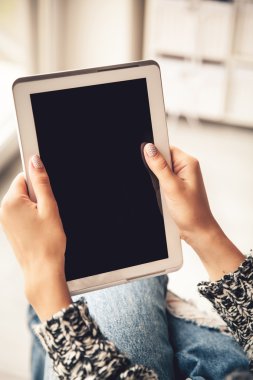 Holding ve boş ekran ile tablet kullanarak kadın yırtık kot pantolon