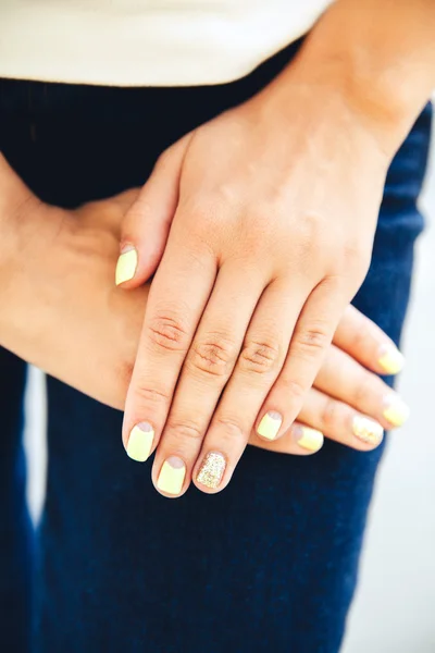Mão feminina com unhas coloridas elegantes, jeans de moda, manicure — Fotografia de Stock