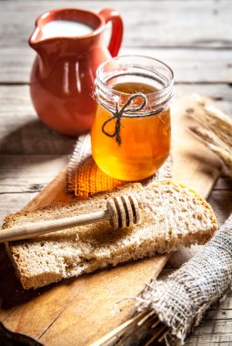 Bir kavanoz bal, dilim ekmek, buğday ve süt
