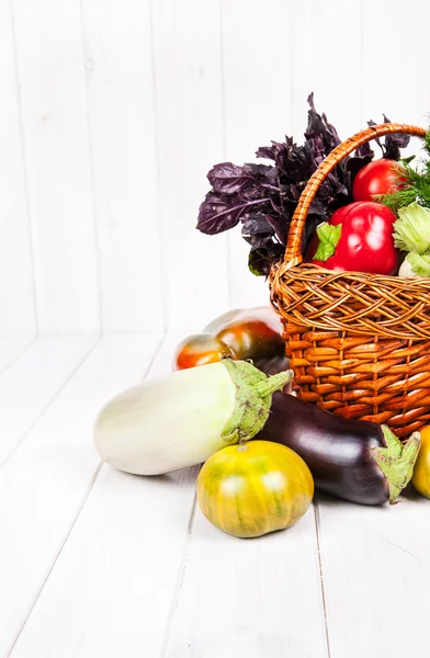 Fresh vegetables in the basket on white wooden background — Stock Photo, Image