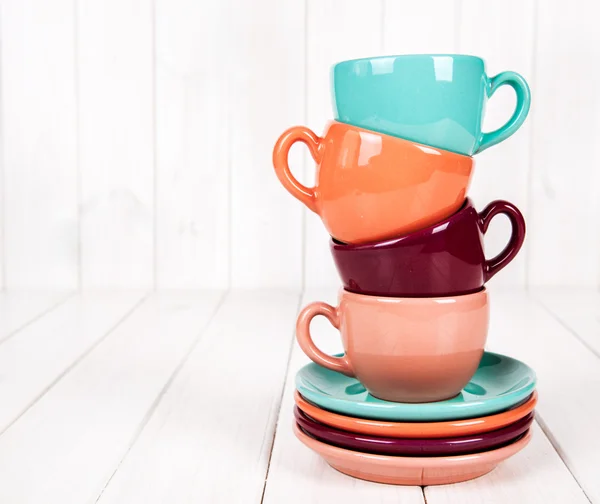 Coloridas tazas de café sobre fondo de madera blanca — Foto de Stock