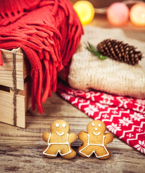 Christmas set. Warm blanket, sweater, socks, garland and a bump on the wooden background