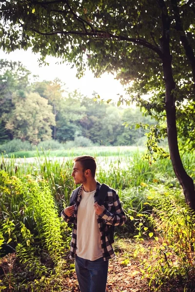 Портрет молодого красивого мужчины с рюкзаком странник прогулка по лесу — стоковое фото
