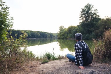 Genç adam ayakta yalnız açık seyahat yaşam konsepti ile göl