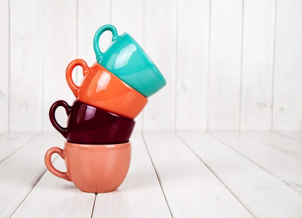 Colored cups on a wooden white background. coffee concept — Stock Photo, Image