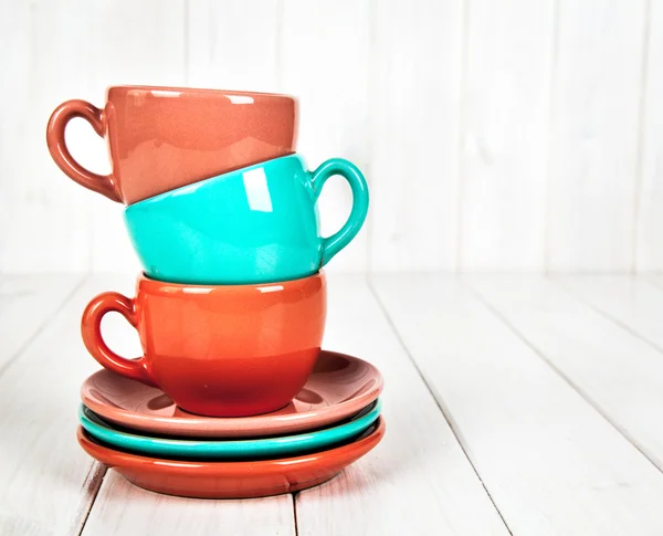Coloridas tazas de café sobre fondo de madera blanca — Foto de Stock