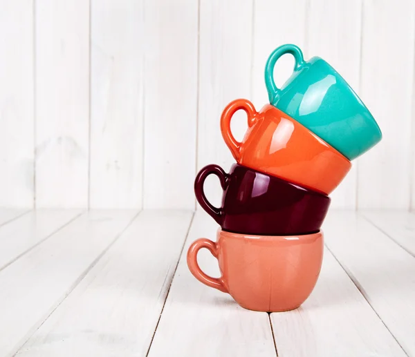 Colored cups on a wooden white background. coffee concept — Stock Photo, Image