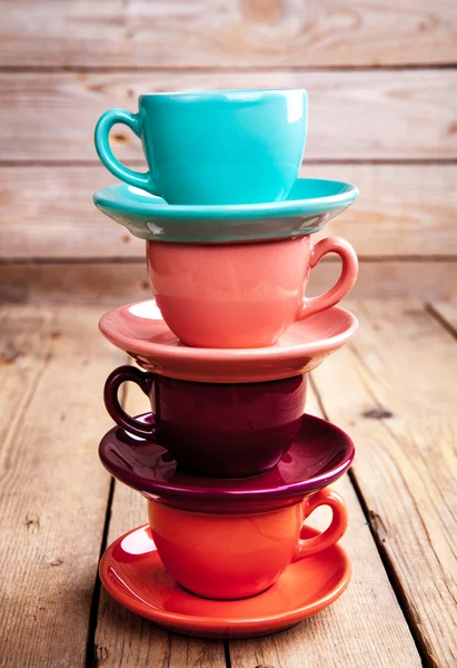 Красочные кофейные чашки на деревянном столе на фоне гранжа — стоковое фото
