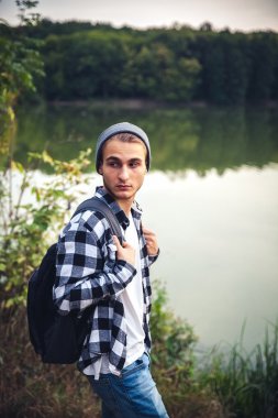 Genç adam ayakta yalnız açık seyahat yaşam konsepti ile göl