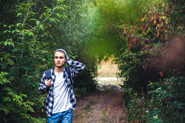 森の中でバックパック放浪者で若いハンサムな男の肖像を歩く — ストック写真