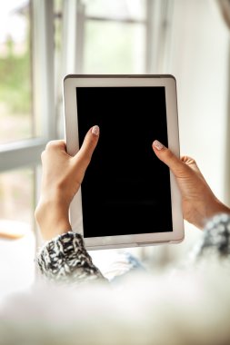 Holding ve boş ekran ile tablet kullanarak kadın yırtık kot pantolon