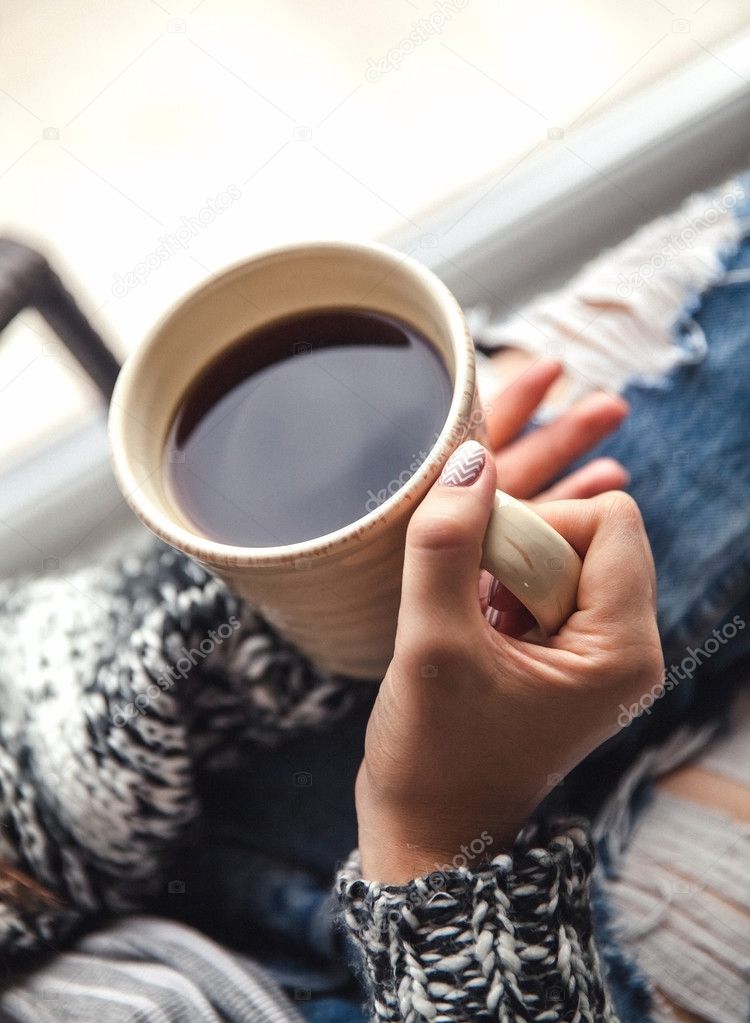 Girl's hands holding a cup of coffee