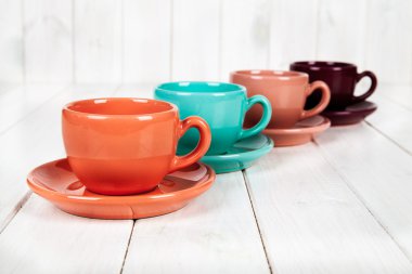 ahşap beyaz arka plan üzerinde renkli bardak. kahve kavramı