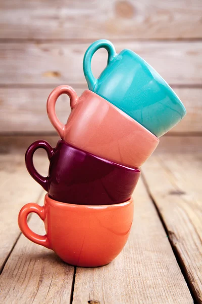 Coloridas tazas de café sobre mesa de madera sobre fondo grunge — Foto de Stock