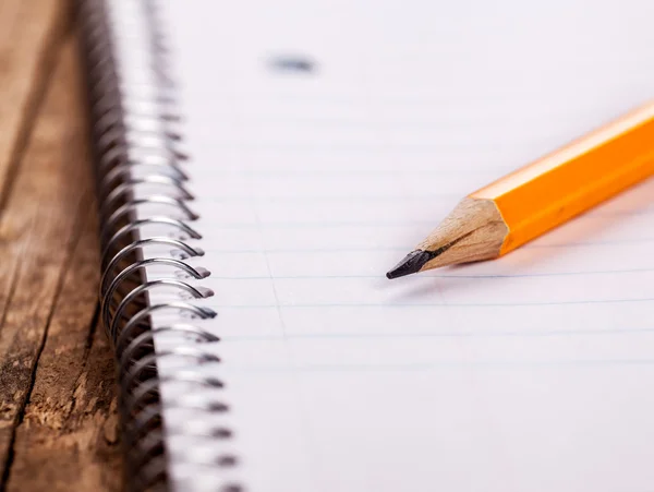 Lápis e um caderno de perto — Fotografia de Stock
