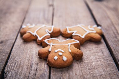 Üç zencefilli kurabiye adam yüksek açı bakış rustik beyaz mutfak masası üzerinde. düz ve buzlanma olmadan kurabiyeler.