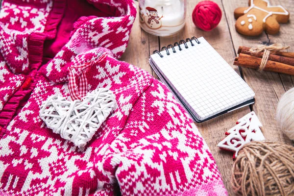 Set de Navidad. Manta caliente, suéter, vela, cuaderno, especias, canela, conos de pino, corazón en el fondo de madera — Foto de Stock