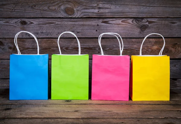 Multicolor Bolsas de compras sobre fondo de madera, venta, compra — Foto de Stock