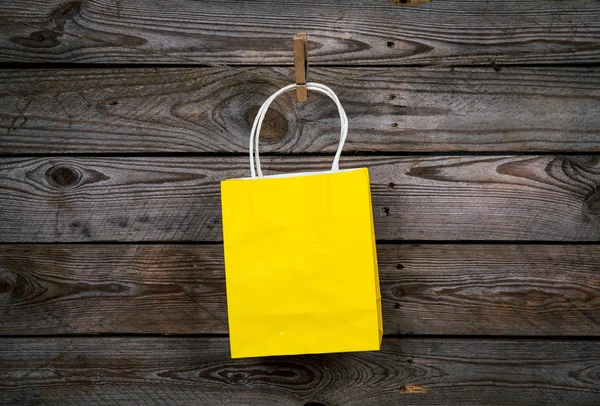 Gele boodschappentas op een houten achtergrond, verkoop, aankoop — Stockfoto