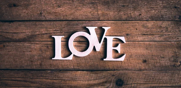 Ordet "kærlighed" på en gammel træplanke. St. Valentinsdag - Stock-foto