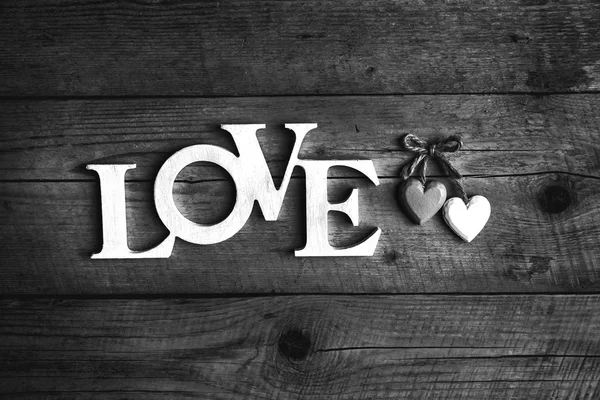 Letras de madera que forman la palabra AMOR escrita sobre fondo de madera. Día de San Valentín. dos corazones — Foto de Stock