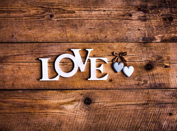 Letras de madeira formando palavra AMOR escrito em fundo de madeira. Dia de São Valentim. dois corações — Fotografia de Stock