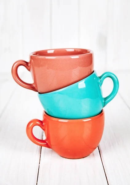 Цветные чашки на деревянном белом фоне. Концепция кофе — стоковое фото