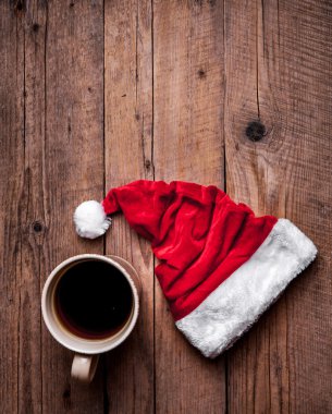 Fincan kahve ve bir ahşap arka plan, kutlama Noel babalar şapka