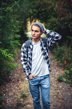 Sırt çantası avare ile genç yakışıklı adam portresi ormanın içinde yürümek