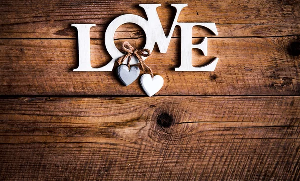 Wooden letters forming word LOVE written on wooden background. St. Valentine's Day. two hearts — Stock Photo, Image