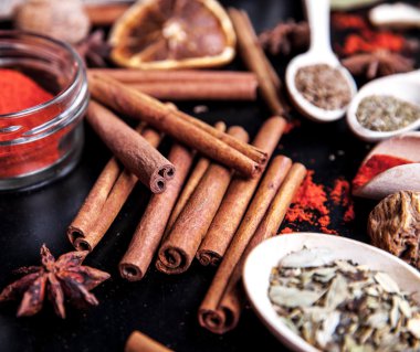 siyah arka plan üzerine baharat ile tahta kaşıklar
