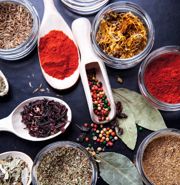 Spices on black background in special jars. Food — Stock Photo, Image