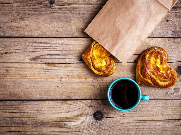 Pâtisseries maison. coeur de chignon dans un sac en papier. pour le petit déjeuner avec café. Matin, boissons, nourriture — Photo